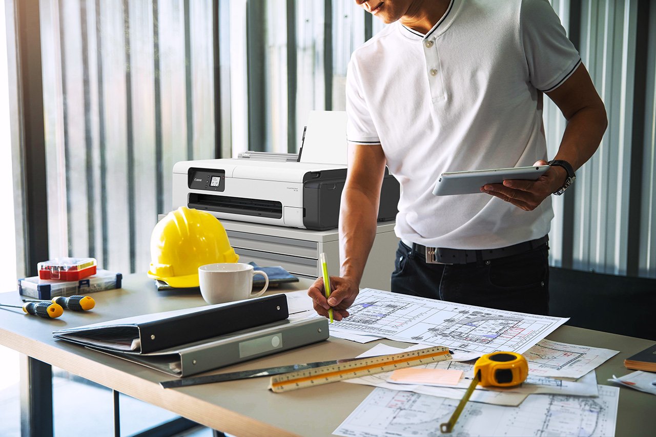 Architects,engineer holding pen pointing equipment architects On Canon imagePROGRAF TC-20